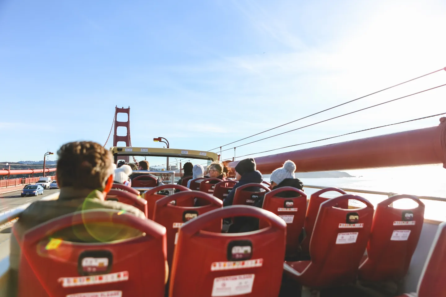 Visitors riding an open-top sightseeing bus in San Francisco
